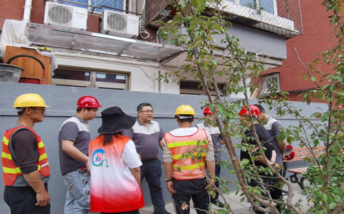 路鵬達黨支部為砂石廠社區修復居民樓外立面保溫層加裝空調冷凝管